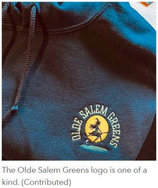 Logo on a sweatshirt of a witch riding a golf club like a broomstick